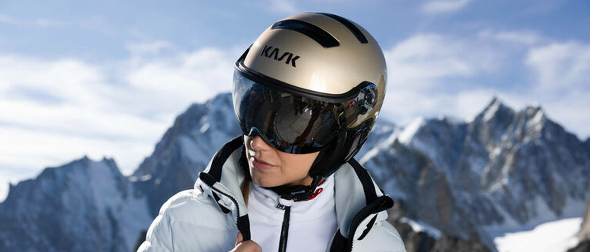 Woman wearing a Kask Treasure model visor ski helmet in a snowy mountain setting