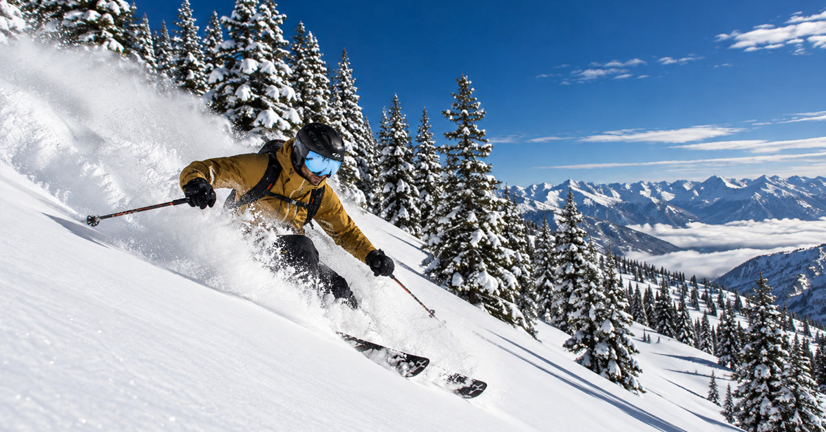 man skiing with a visor ski helmet on fresh snow and pine trees