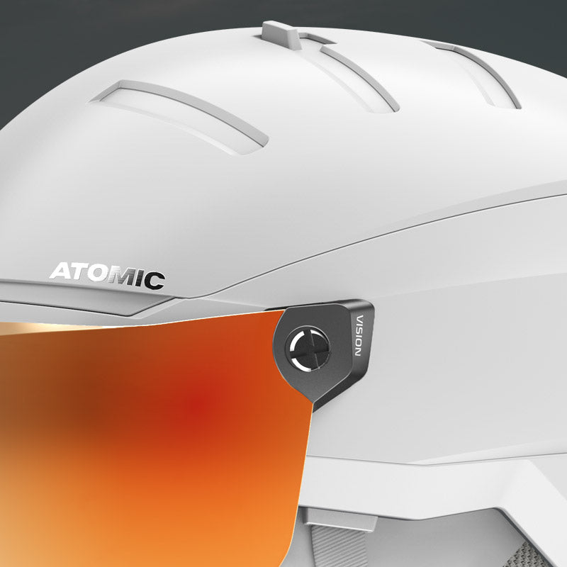 Close-up of vents on a white visor ski helmet with orange visor and 'Atomic' branding on a dark background