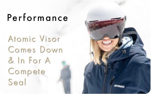 Woman wearing a white Atomic visor ski helmet and blue ski jacket