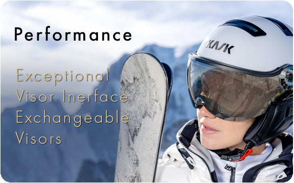 Woman holding a pair of skis with white all in one ski helmet from Kask on