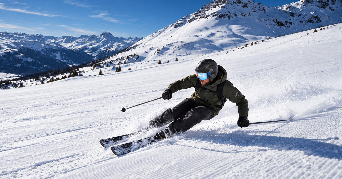 man skiing on a groomed ski run with a carbon visor ski helmet